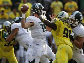 Michigan St. QB Connor Cook throws downfield under pressure from Oregon DL Tony Washington. Oregon beat MSU in Eugene, OR, 46-29.  Associated Press